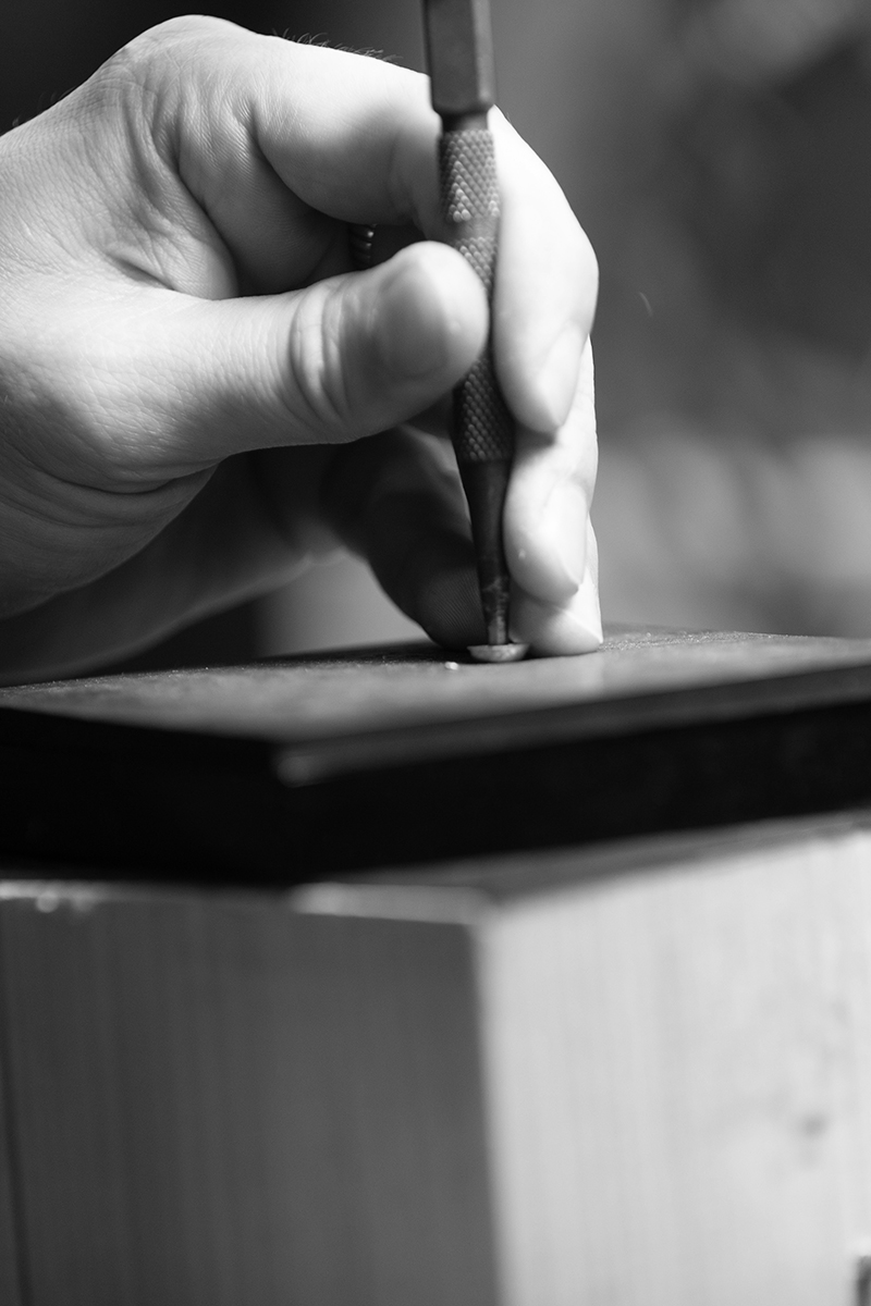 Close-up of the artisan's hands working on a piece.
